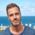 Author Reece Carter standing on a hill with the ocean in the background