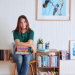 Young adult fiction author and ​​Australian Writers' Centre graduate Miranda Luby with a pile of books.